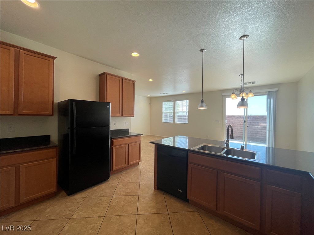 10632 Summerbell Street Las Vegas, NV 89179 - Photo 8 of 16 Kitchen featuring black appliances, brown cabinets, light tile patterned floors, hanging light fixtures, and recessed lighting