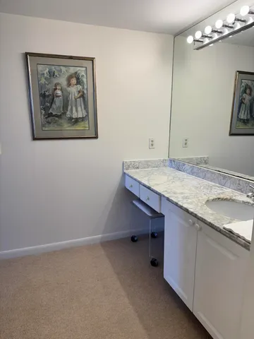 a bathroom with a granite countertop sink a mirror and vanity