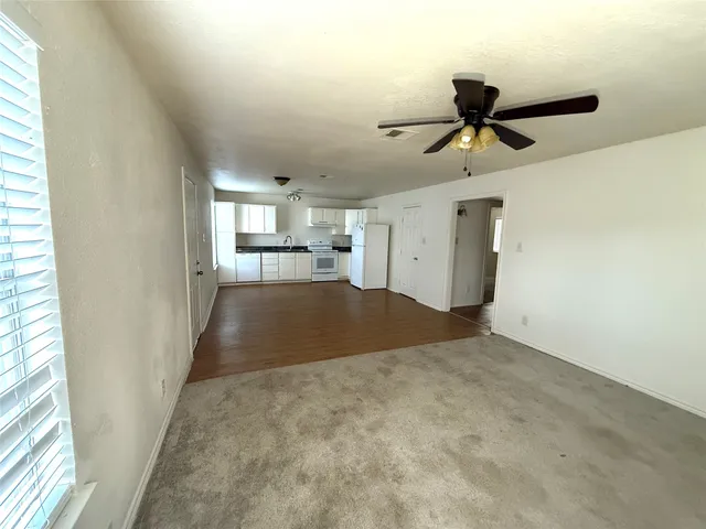 a view of empty room with wooden floor and window