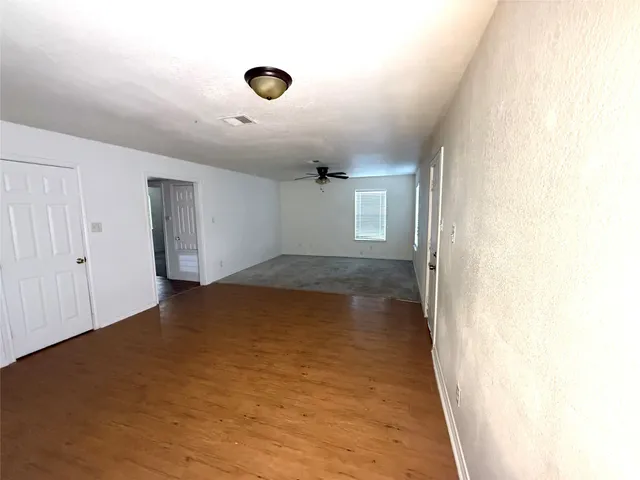 a view of a kitchen with refrigerator and white cabinets