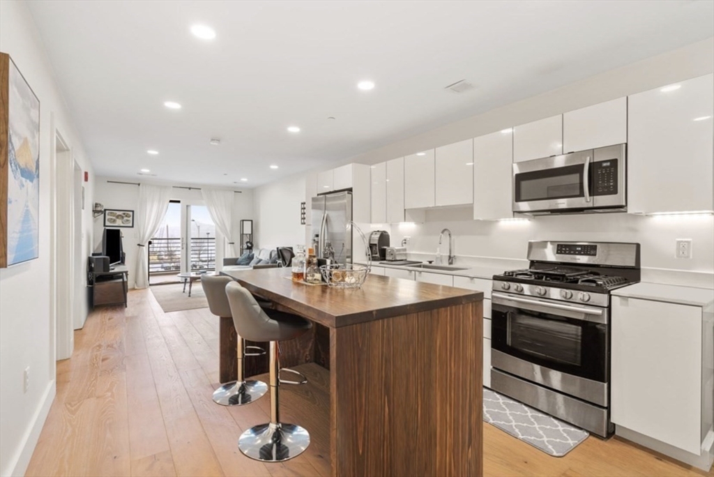 a kitchen with stainless steel appliances granite countertop a sink dishwasher stove top oven and refrigerator