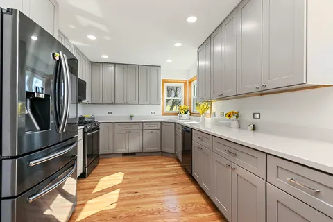 a kitchen with stainless steel appliances granite countertop a sink refrigerator and cabinets