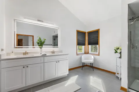 a en suite bathroom with a double vanity sink and a window