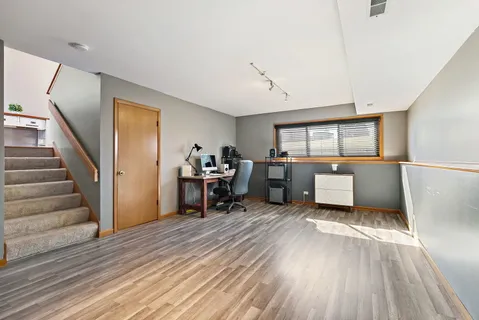 a view of a room with chairs and wooden floor