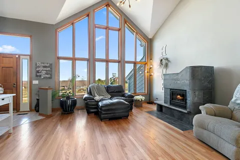 a living room with furniture a fireplace a flat screen tv and a large window