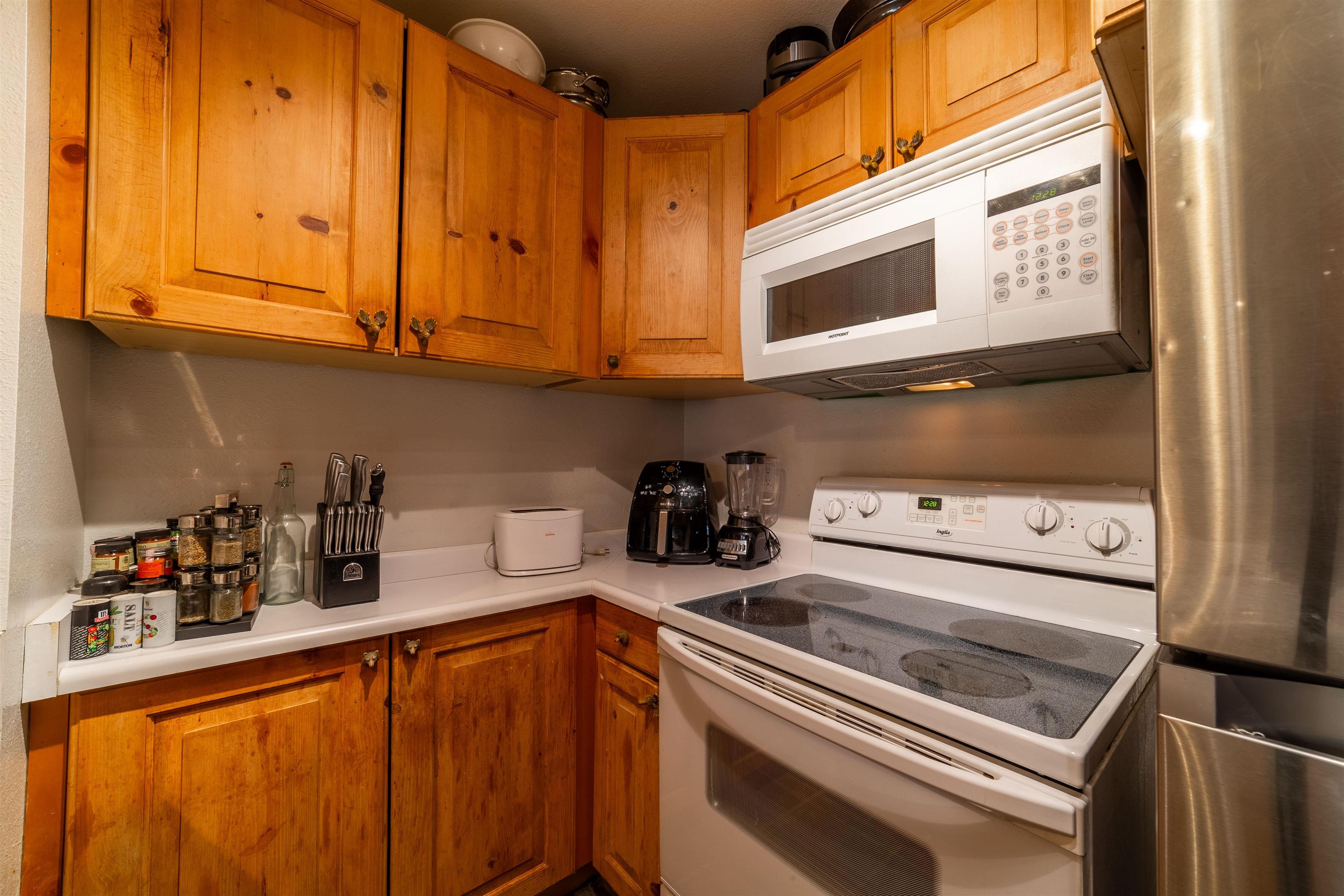 3253 Meridian Boulevard, Unit 214 Mammoth Lakes, CA 93546 - Photo 11 of 28 a kitchen with stainless steel appliances cabinets and a window