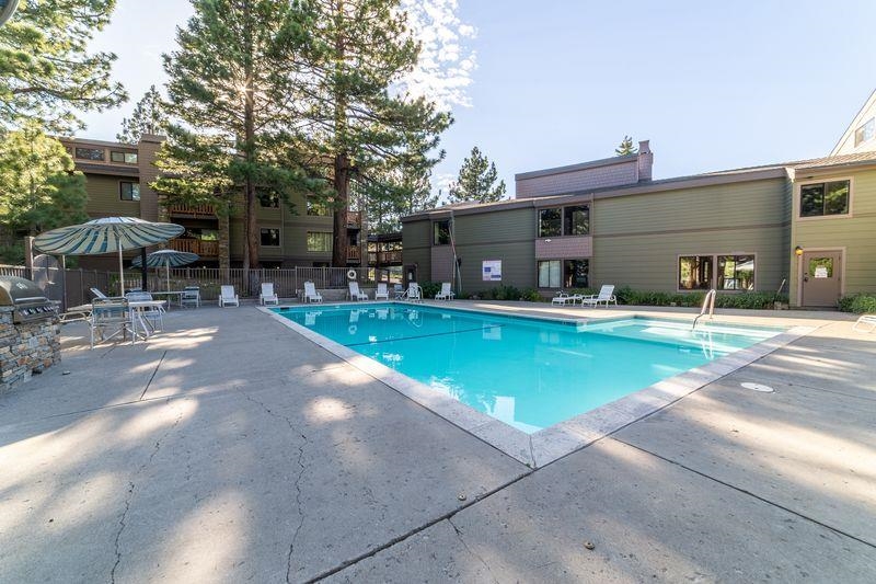 3253 Meridian Boulevard, Unit 214 Mammoth Lakes, CA 93546 - Photo 22 of 28 a view of a patio with a table and chairs under an umbrella