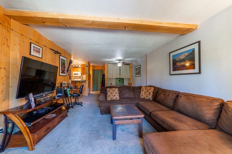 3253 Meridian Boulevard, Unit 214 Mammoth Lakes, CA 93546 - Photo 7 of 28 a living room with furniture and a flat screen tv