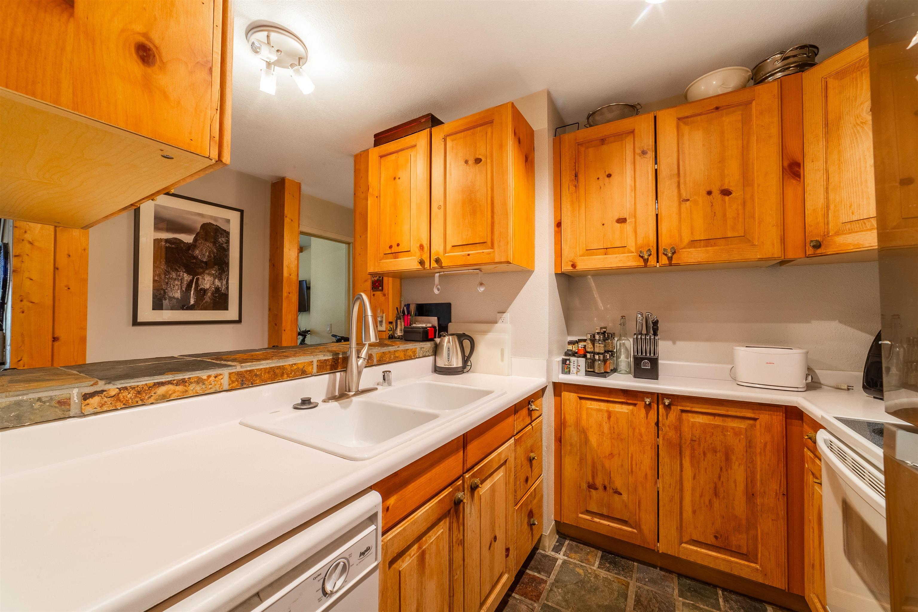 3253 Meridian Boulevard, Unit 214 Mammoth Lakes, CA 93546 - Photo 9 of 28 a kitchen with a sink a stove and cabinets