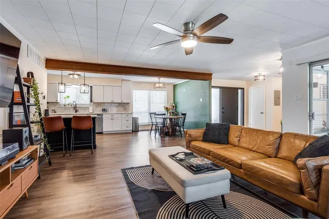 a living room with furniture kitchen view and a large window