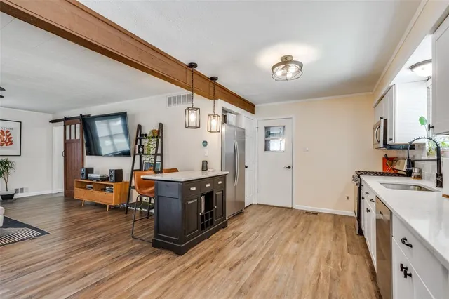 a large kitchen with stainless steel appliances granite countertop a lot of counter space and wooden floors