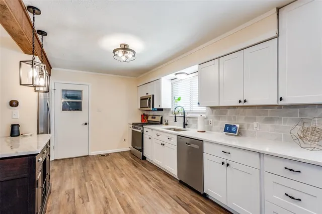 a kitchen with cabinets wooden floor and a sink