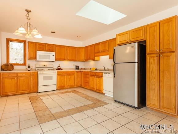 104 Hampton Road Leicester, NC 28748 - Photo 6 of 19 a kitchen with a refrigerator a stove top oven a sink and cabinets
