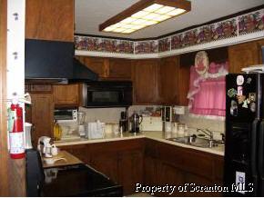 309 Gravity Road Lake Ariel, PA 18436 - Photo 3 of 6 a kitchen with a stove a microwave and cabinets