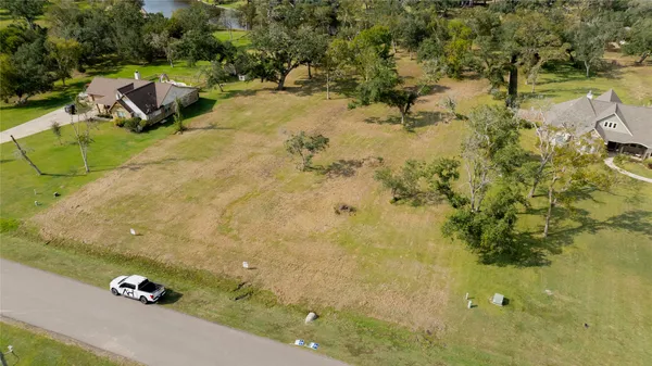 an aerial view of a residential houses with yard