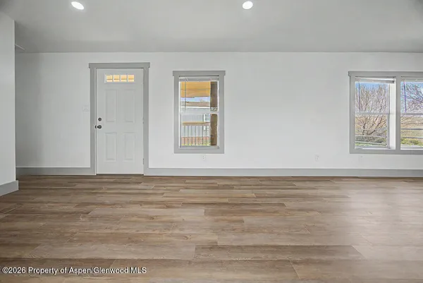 a view of a room with wooden floor and window
