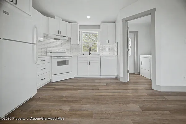 a kitchen with white cabinets and white appliances