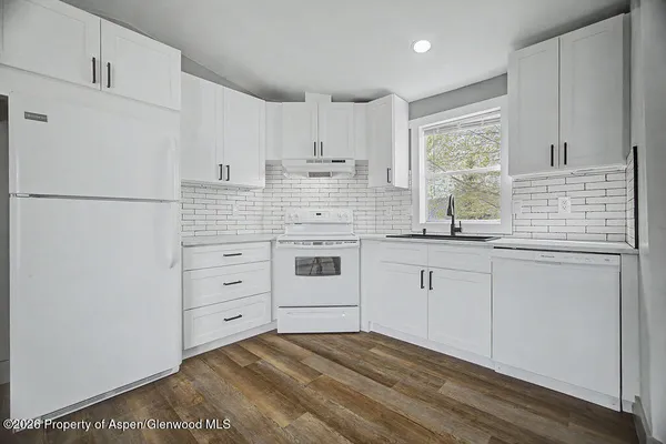 a kitchen with white cabinets and white appliances