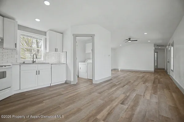 a view of a kitchen with wooden floor and electronic appliances