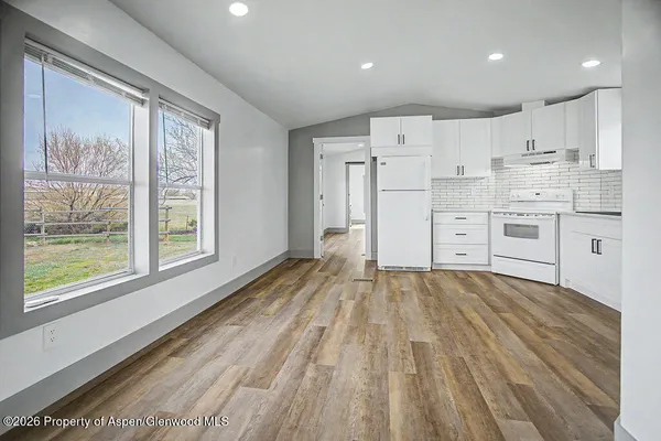 a view of kitchen with wooden floor and electronic appliances