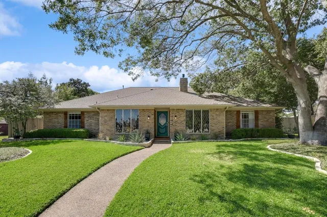 a view of a house with a yard and tree s