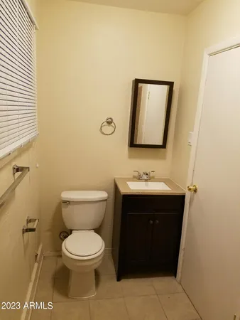 a bathroom with a toilet sink vanity and mirror