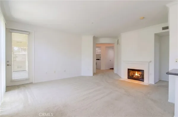 an empty room with a fireplace and window