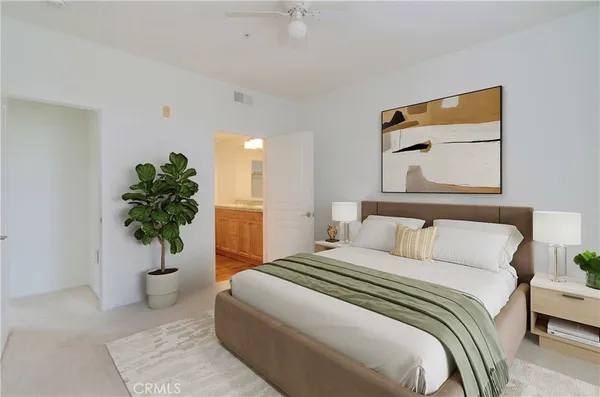a bedroom with a large bed and a potted plant
