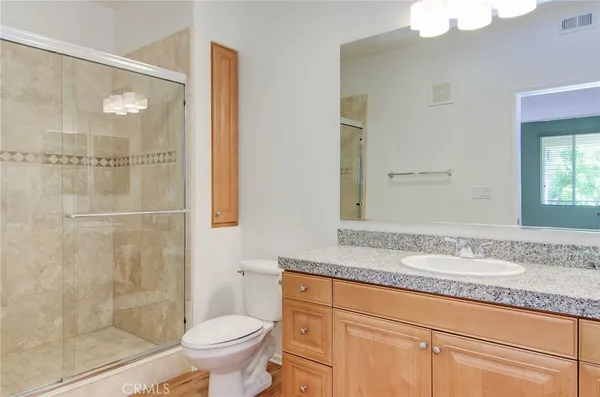 a bathroom with a granite countertop sink a toilet and shower