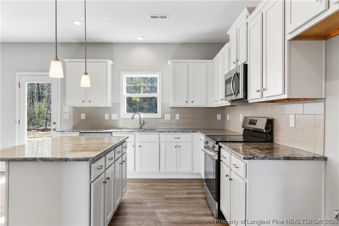 254 Collier Street Linden, NC 28356 - Photo 6 of 34 a kitchen with stainless steel appliances granite countertop a sink stove and cabinets