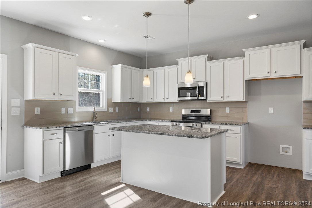 254 Collier Street Linden, NC 28356 - Photo 7 of 34 a kitchen with stainless steel appliances granite countertop a sink a stove a microwave and cabinets
