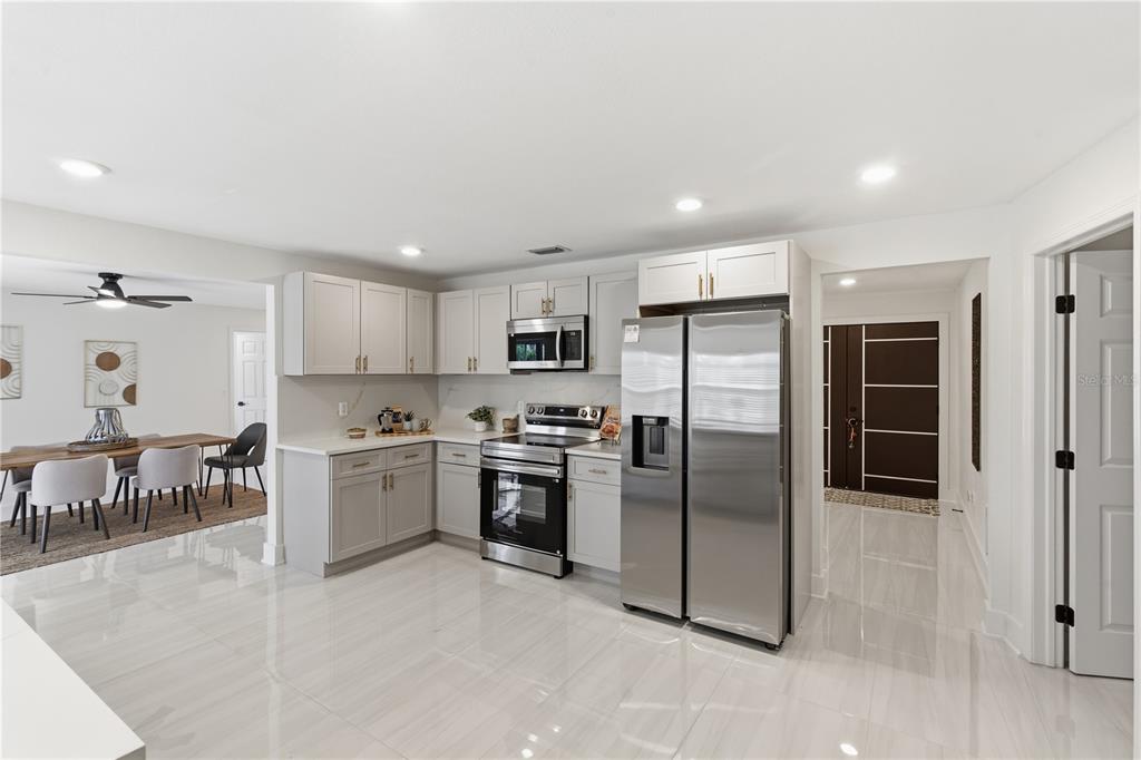 4346 Marine Parkway New Port Richey, FL 34652 - Photo 12 of 51 a kitchen with stainless steel appliances granite countertop a refrigerator and a stove top oven