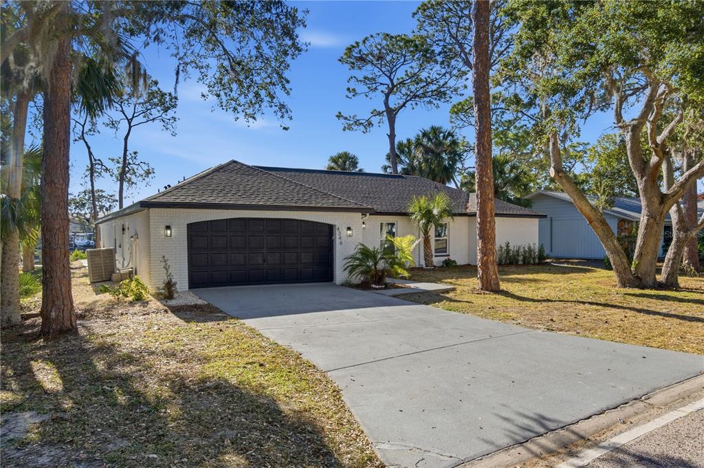 4346 Marine Parkway New Port Richey, FL 34652 - Photo 2 of 51 a front view of a house with a yard and garage
