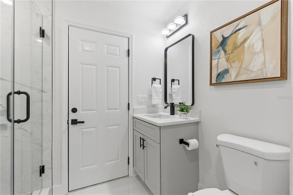 4346 Marine Parkway New Port Richey, FL 34652 - Photo 40 of 51 a bathroom with a granite countertop sink a toilet a shower and a mirror