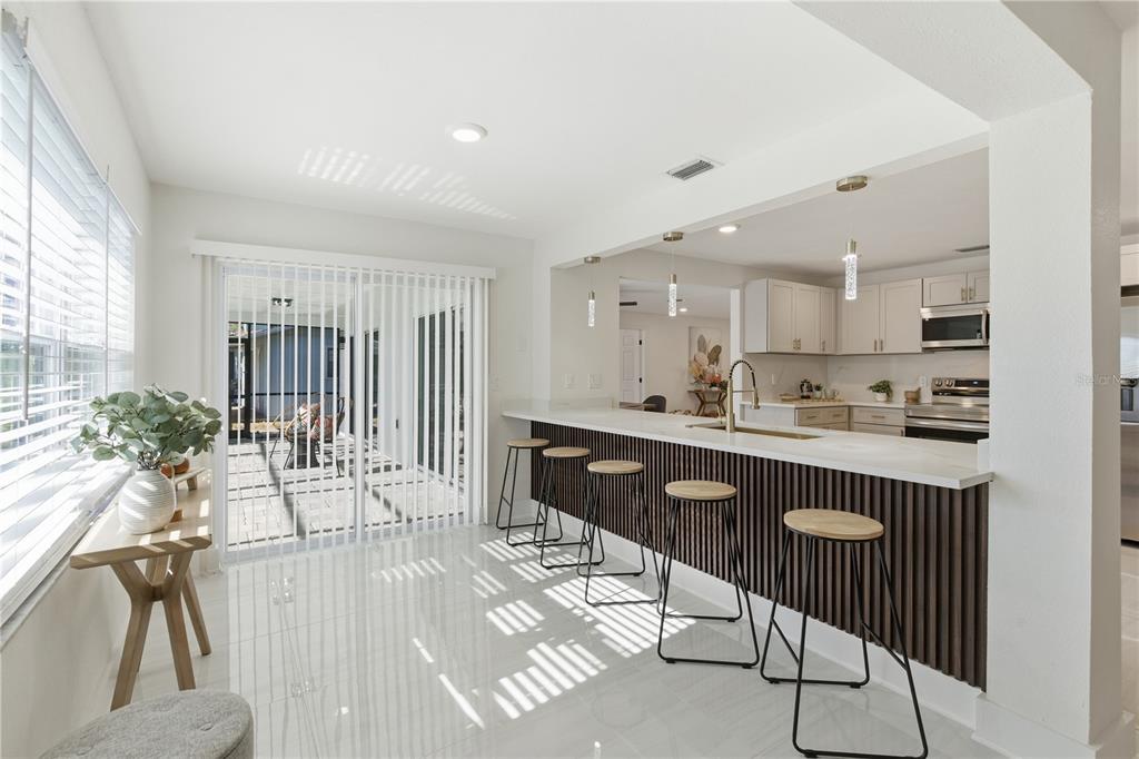 4346 Marine Parkway New Port Richey, FL 34652 - Photo 8 of 51 a kitchen with stainless steel appliances granite countertop a refrigerator a sink a stove a dining table and chairs