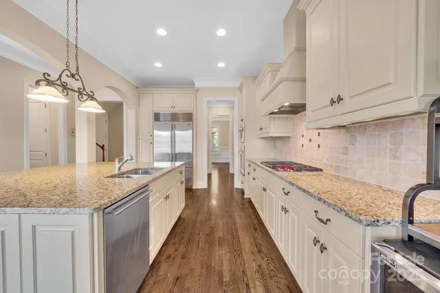 a kitchen with a white wooden cabinets and wooden floor