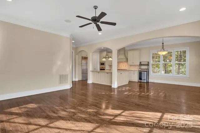 a view of an empty room with window and wooden floor