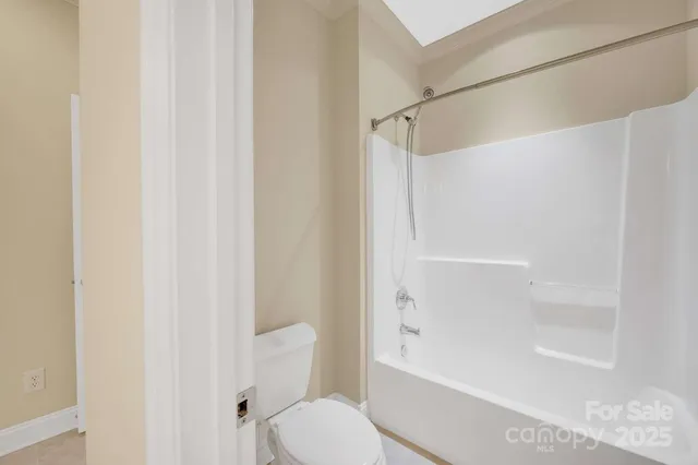 a view of an empty room with closet and a window