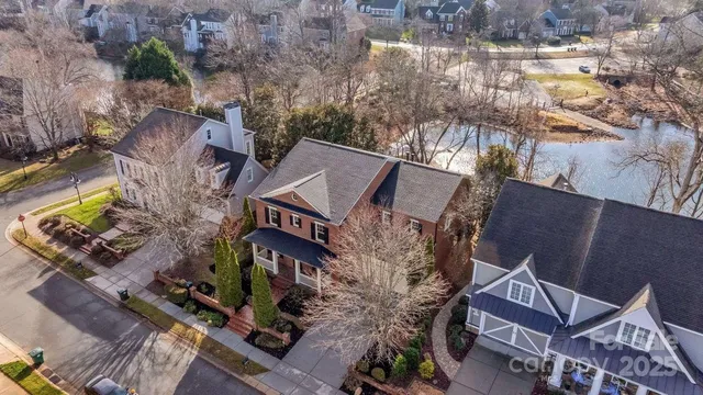 an aerial view of a house with a yard and large trees