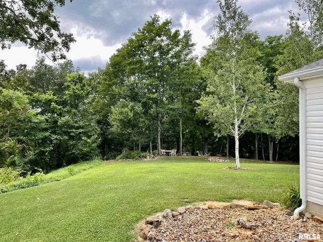 an aerial view of residential house with outdoor space and trees all around