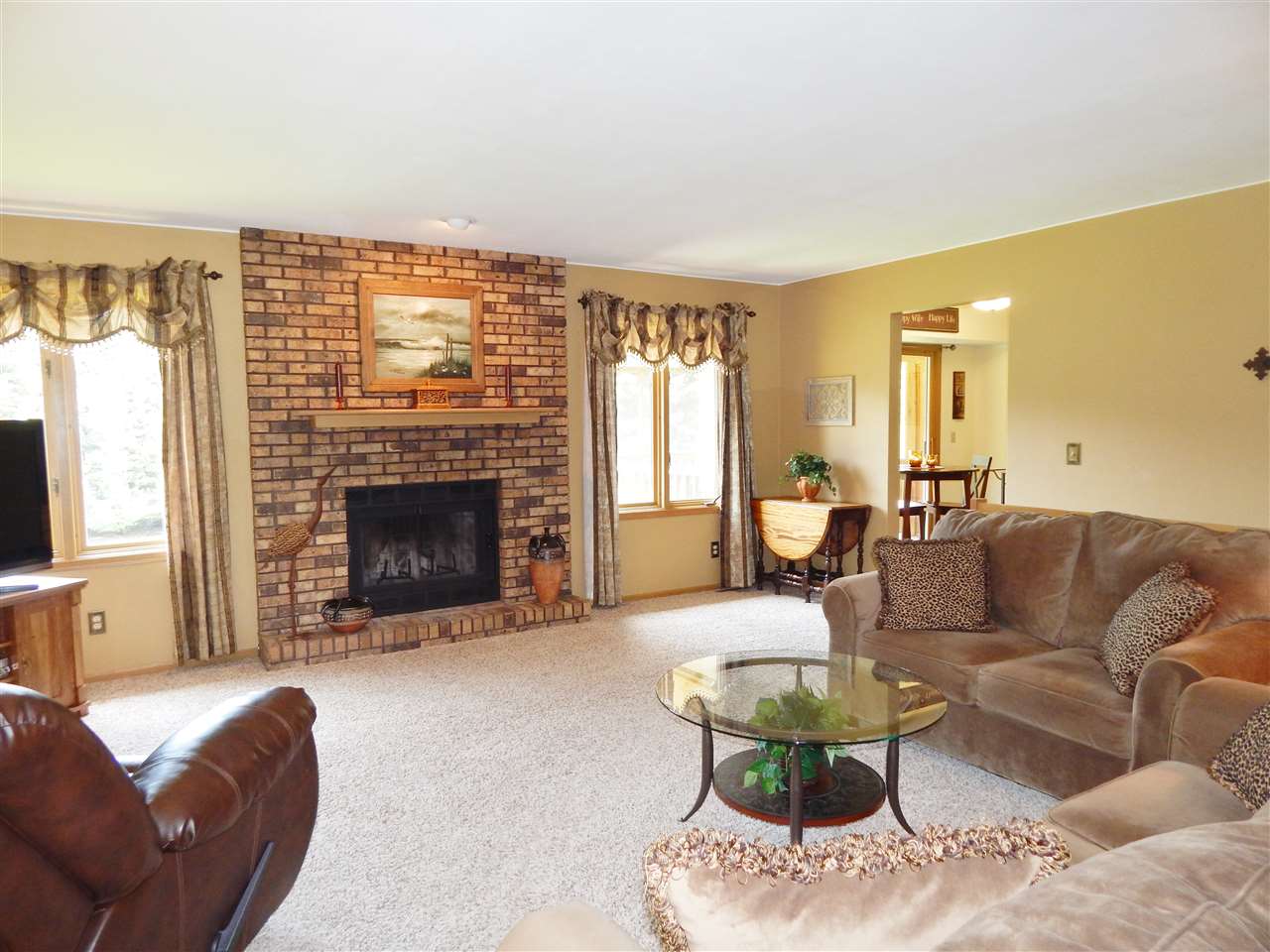4259 Montclair Road Roscoe, IL 61073 - Photo 14 of 25 a living room with furniture a fireplace and a large window