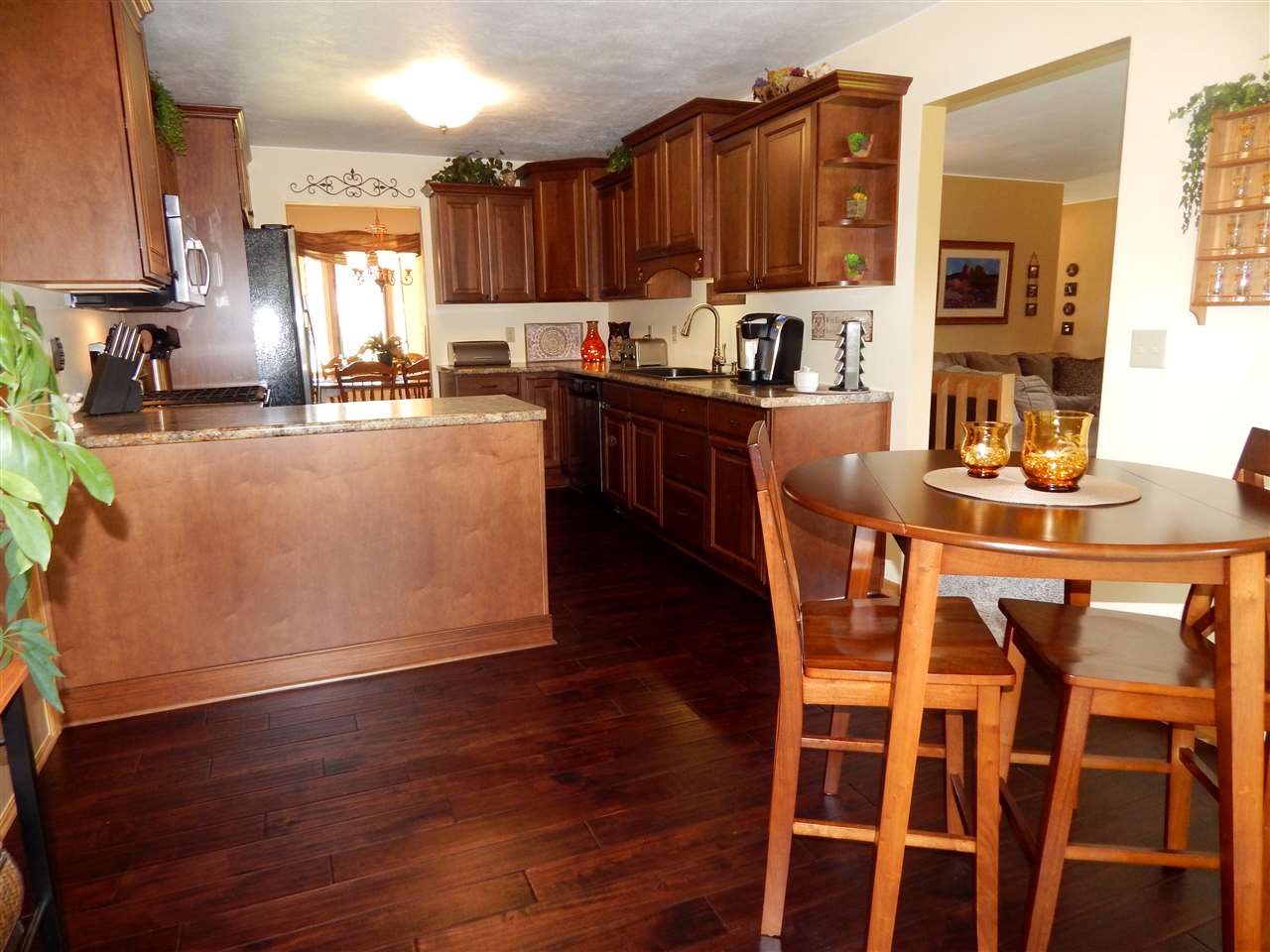 4259 Montclair Road Roscoe, IL 61073 - Photo 7 of 25 a kitchen with stainless steel appliances wooden floors and wooden cabinets