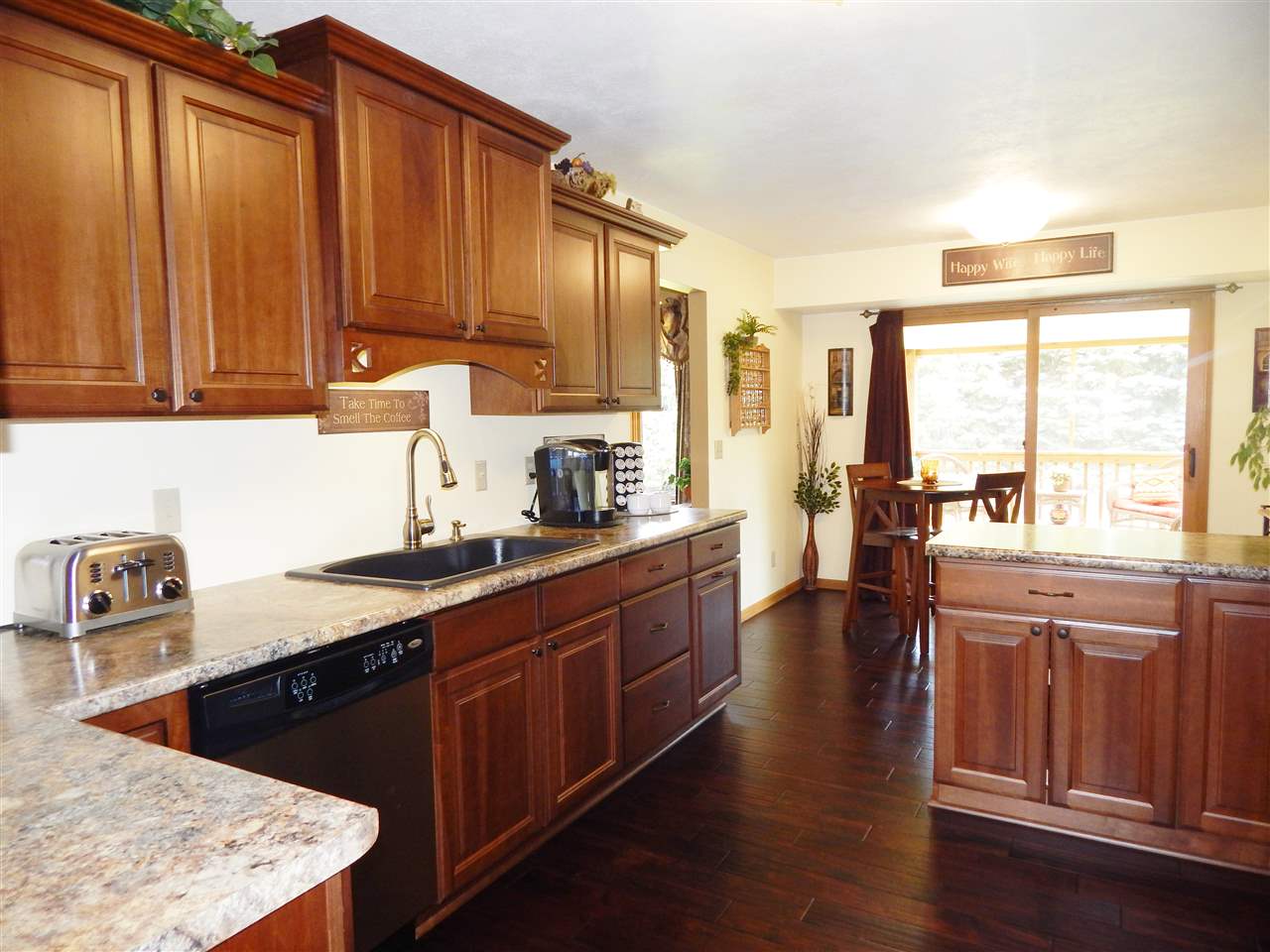 4259 Montclair Road Roscoe, IL 61073 - Photo 10 of 25 a kitchen with stainless steel appliances granite countertop a sink dishwasher stove and wooden cabinets with wooden floor