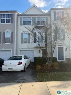 a couple of cars parked in front of a white building