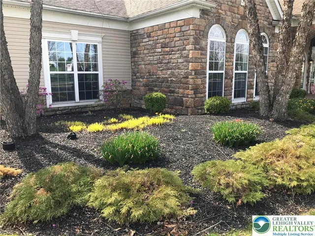 a front view of a house with a yard and potted plants