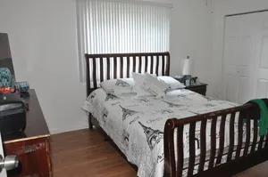 a bed sitting in a bedroom next to a window