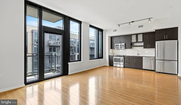 a living room with furniture a large window and dining table