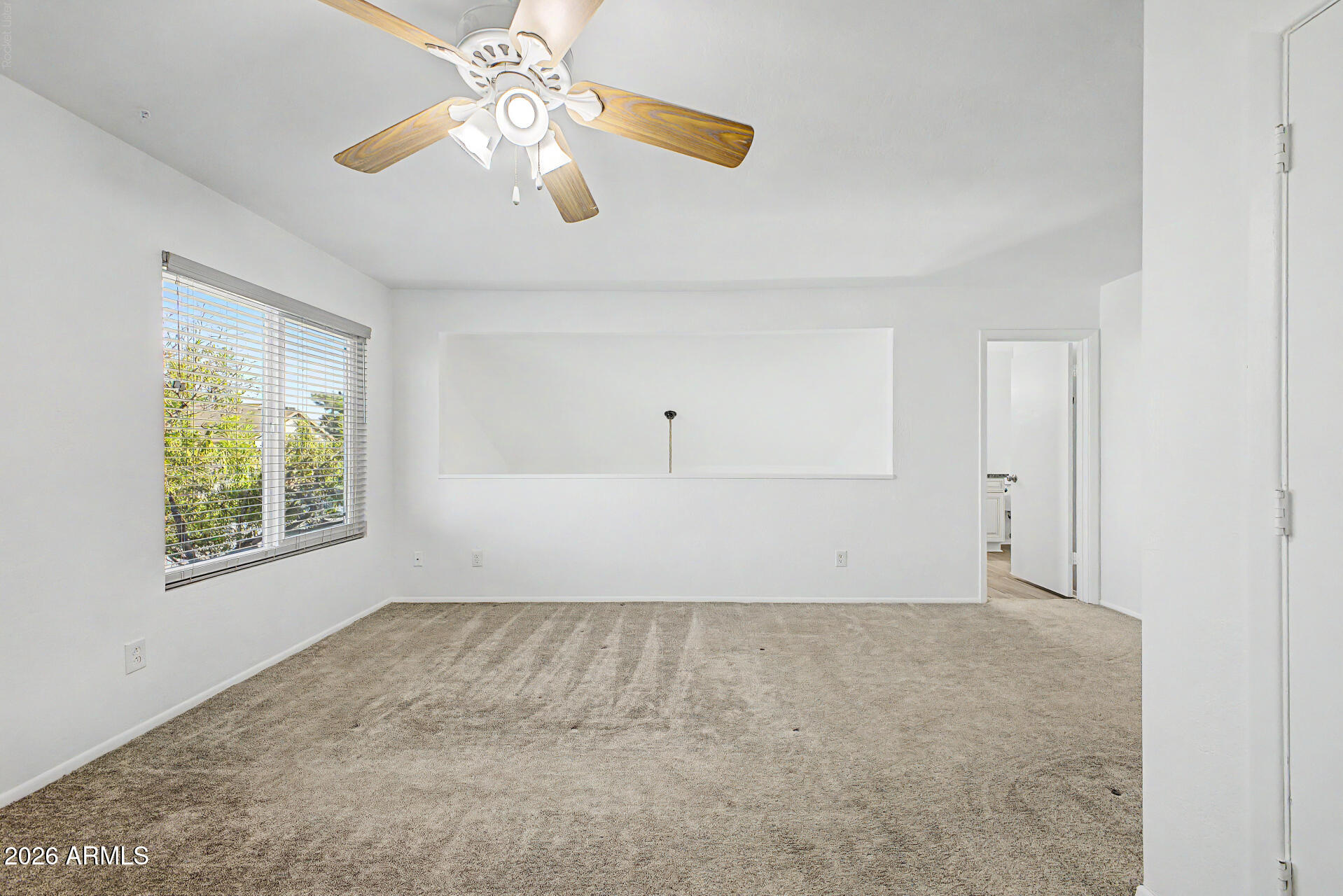 2455 East Broadway Road, Unit 103 Mesa, AZ 85204 - Photo 9 of 22 an empty room with chandelier fan and windows