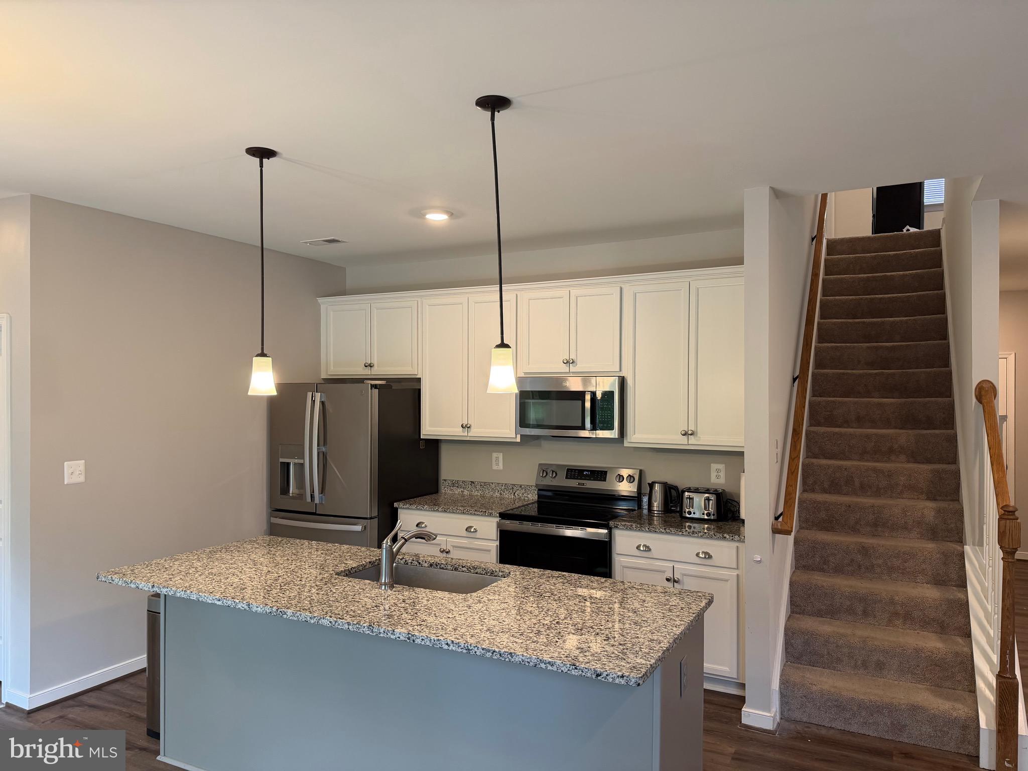 229 Bibb Street Louisa, VA 23093 - Photo 27 of 72 a kitchen with kitchen island granite countertop a sink a counter top space appliances and cabinets