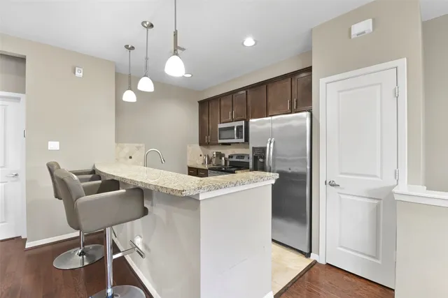a kitchen with a refrigerator a table and chairs in it